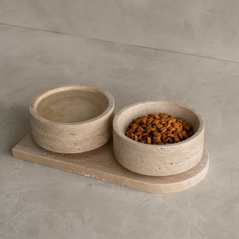 Close-up of travertine pet food bowls on tray - dry pet food in one bowl