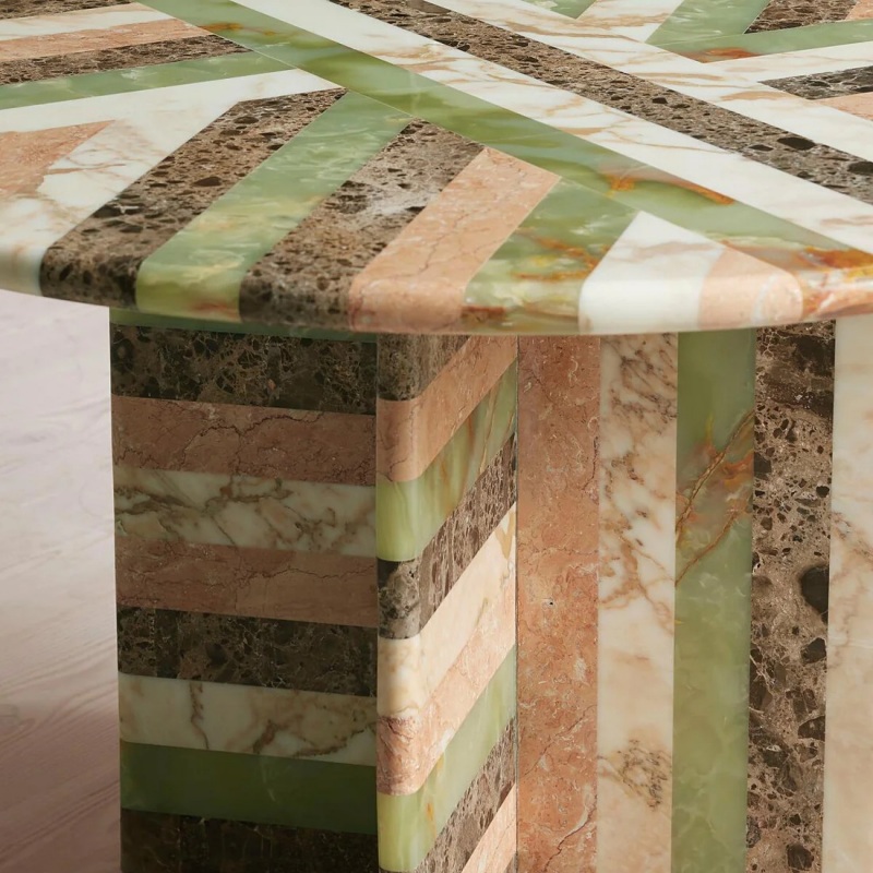 Close-up of multi-marble mosaic table base - layered stone texture & geometric pattern detail