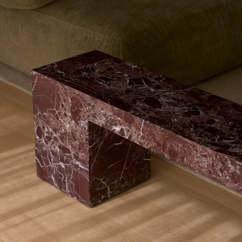 Side view of Burgundy Marble Rectangular Bench - minimalist geometric frame next to green sofa