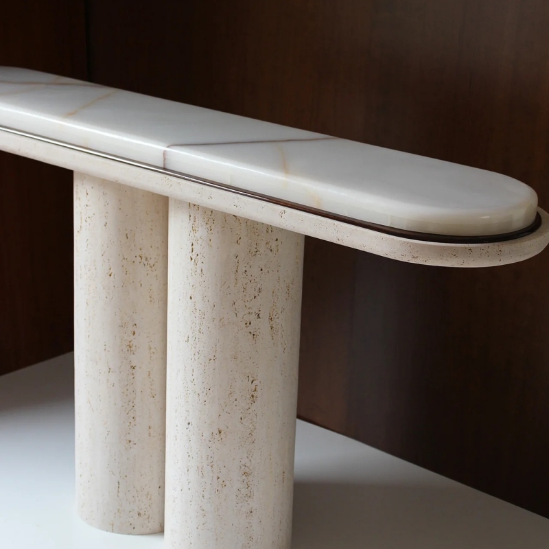 Close-up of White Onyx tabletop on travertine console table - double-layered edge with metal trim detail