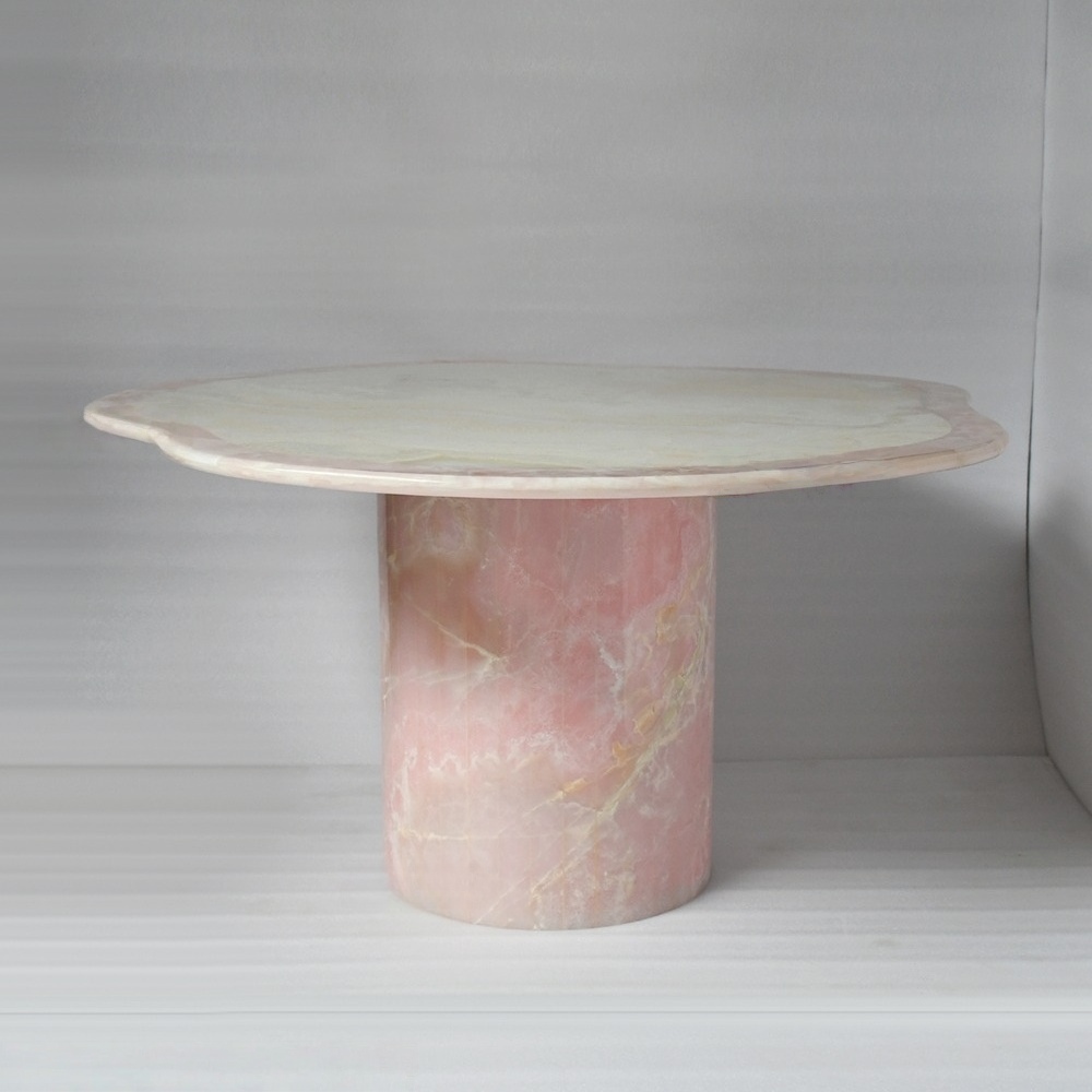 Pink onyx dining table with organic scalloped edge and cylindrical pedestal base